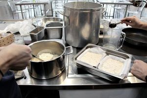 Ladling the curdled milk into prepared boxes